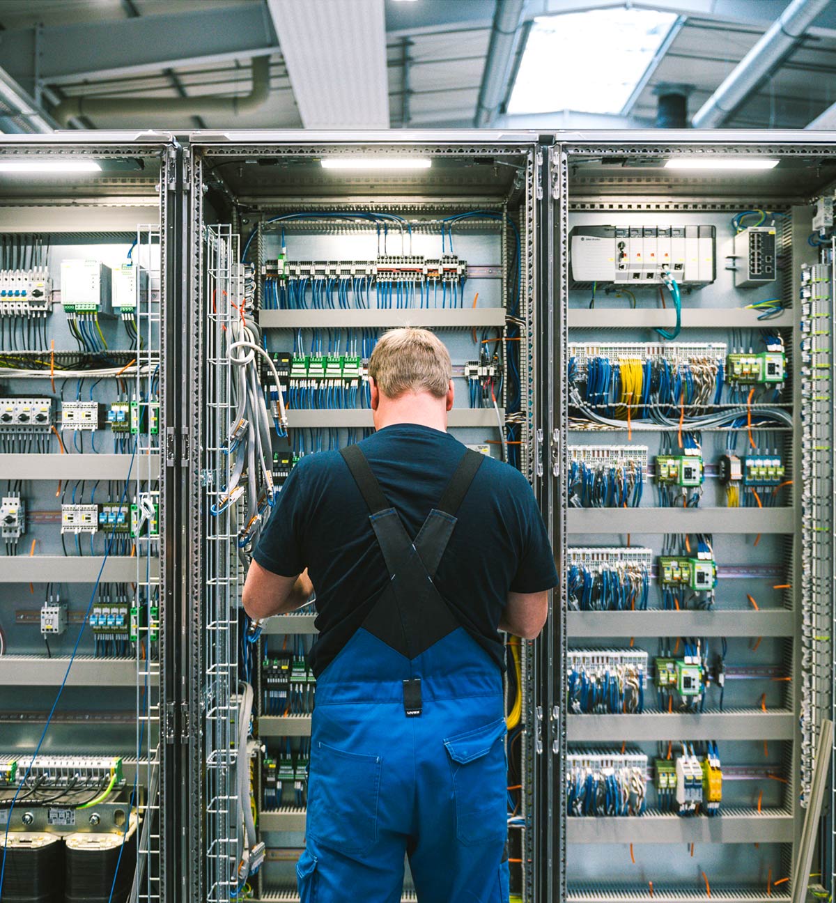Wirtschaftsförderung Elektriker vor großem Schaltschrank